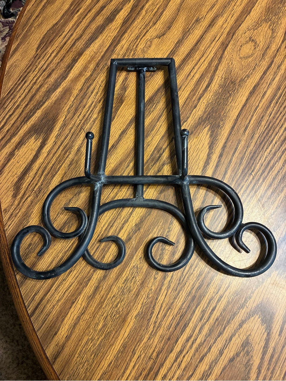 black metal table top easel features an intricate scroll work design - Picture 3 of 6